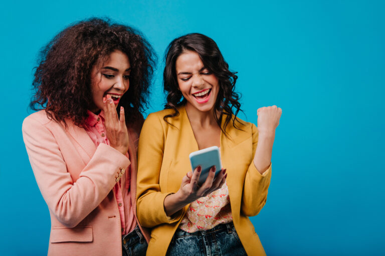 Excited latin woman making selfie with friend
